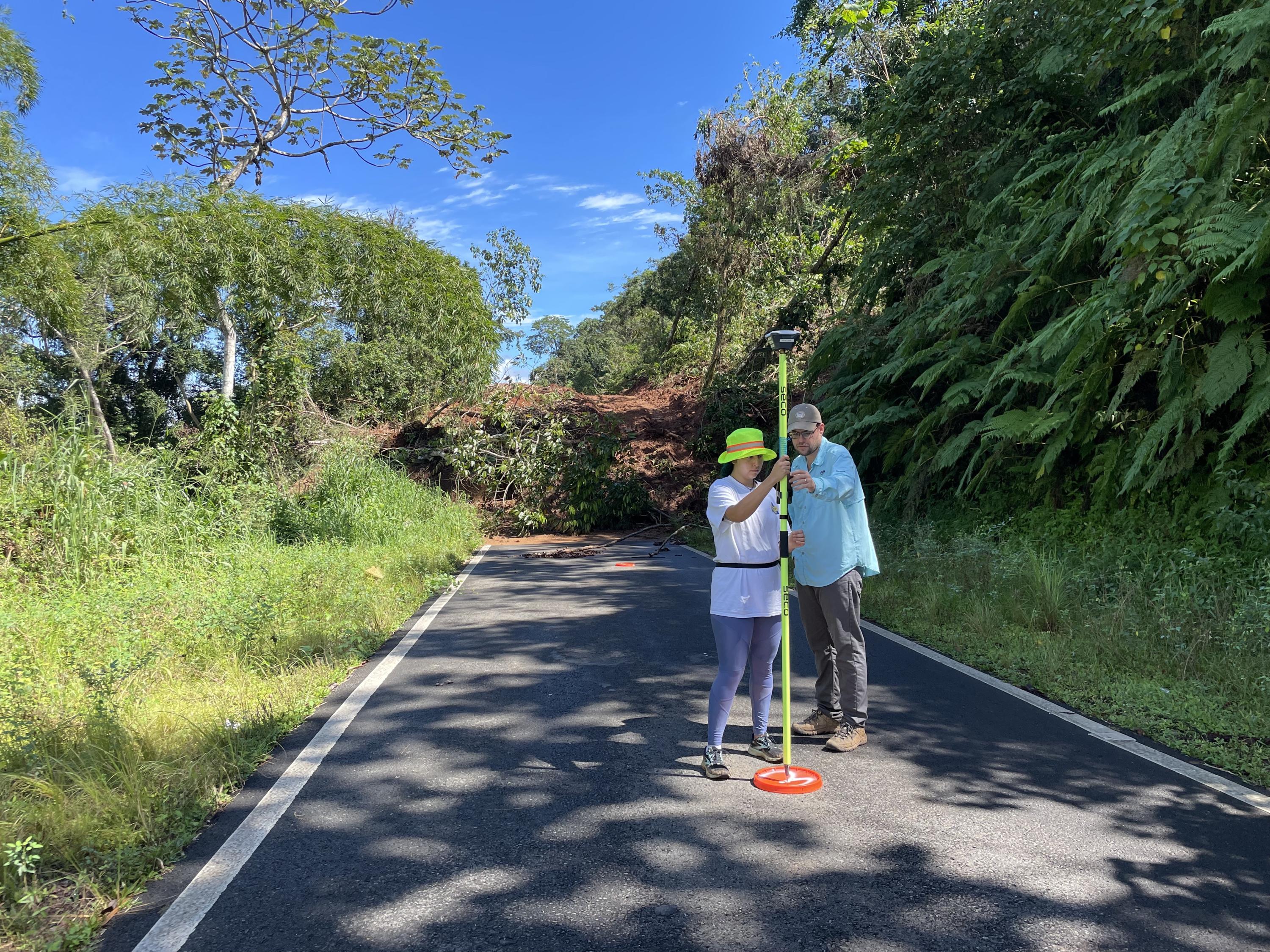 From October '22 Puerto Rico trip: CEE grad student Paola Vargas-Vargas (left) and Stephen Hughes of the University of Puerto Rico, Mayaguez calibrate an instrument in front of a landslide. (Photo Frances Rivera-Hernández)